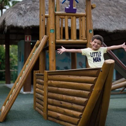 menino brincando em cardo de madeira de brinquedo em playground do Salinas