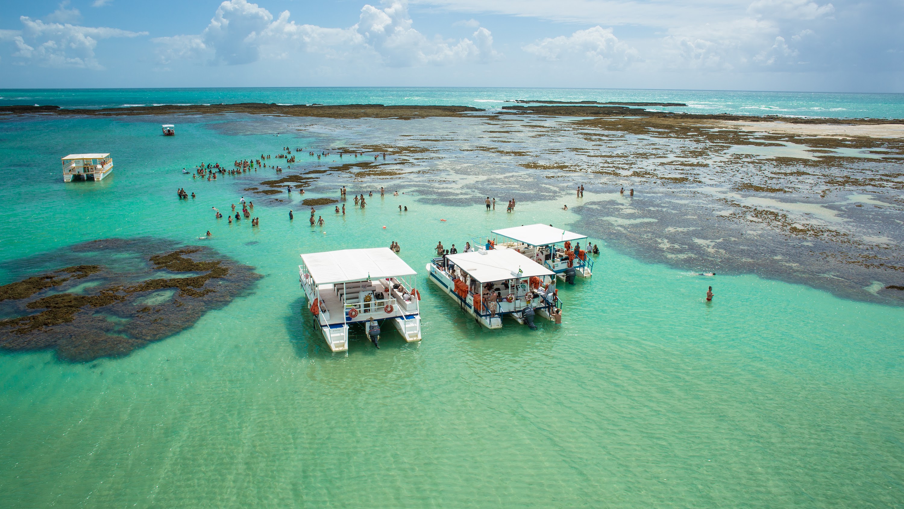 Barcos de passeio as piscinas naturais da praia de Barra Grande, as Galés de Maragogi. 