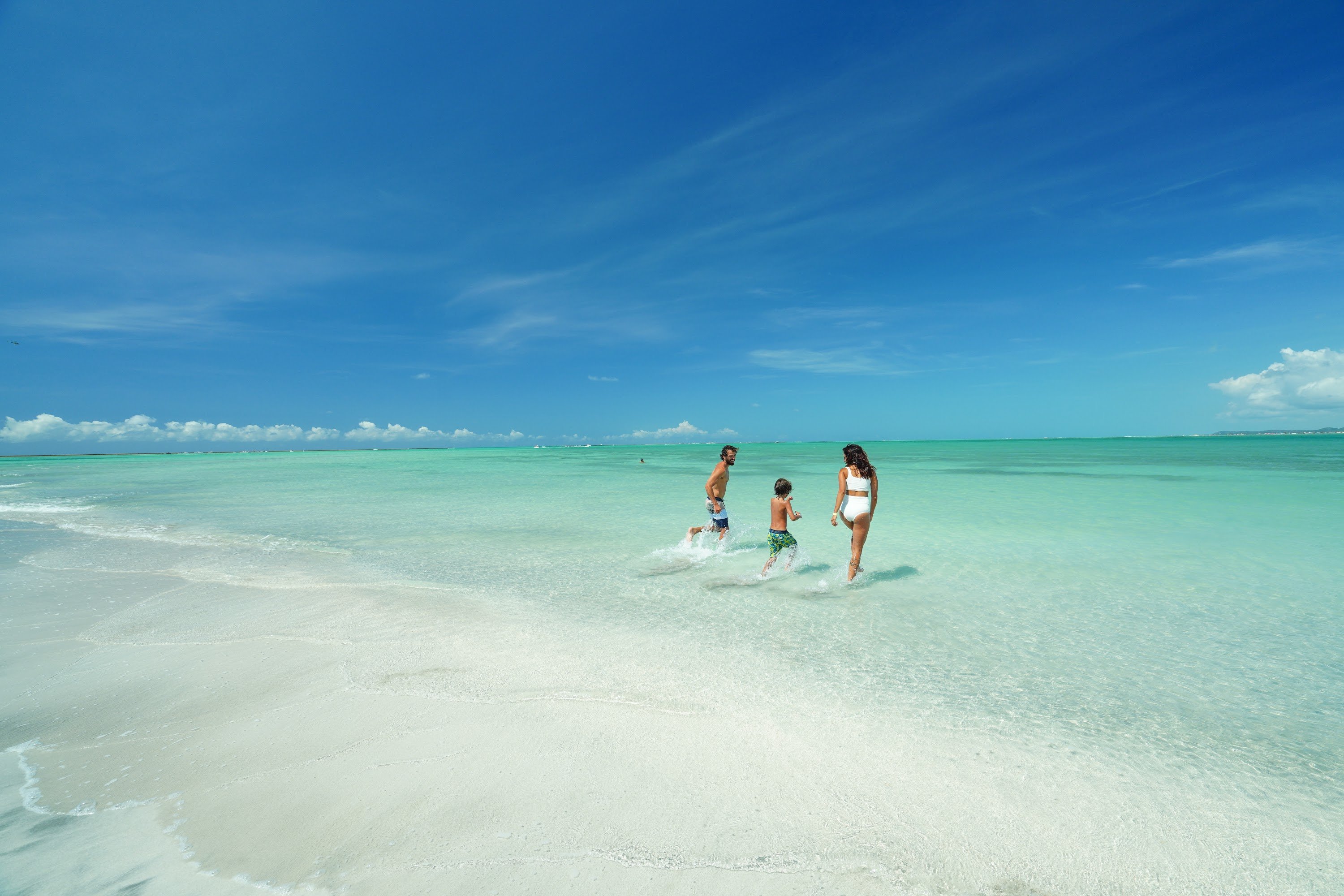 Família caminhando na Praia de Antunes.