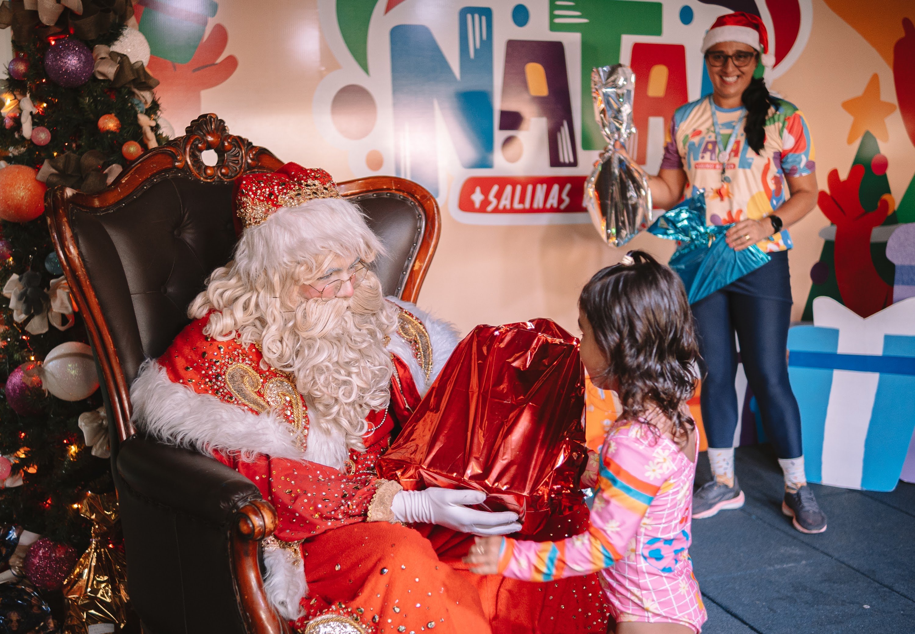 Papai Noel entrega presente a menina em noite de Natal do Salinas Maragogi.