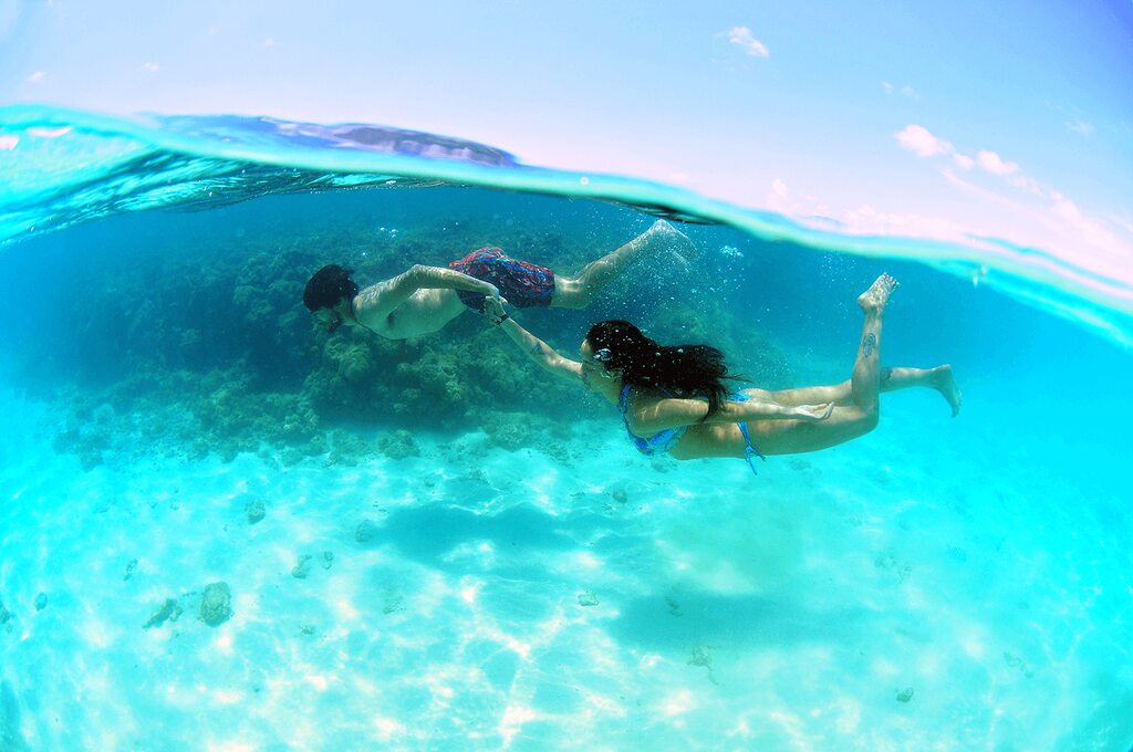 casal mergulhando em piscina natural em Maragogi durante viagem de lua de mel